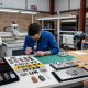 Technician producing bespoke service resin domed badges and custom branded products in a UK manufacturing workshop.