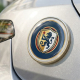 A durable 3D resin-domed car custom badge with a glossy finish mounted on the metallic exterior bodywork of a vehicle